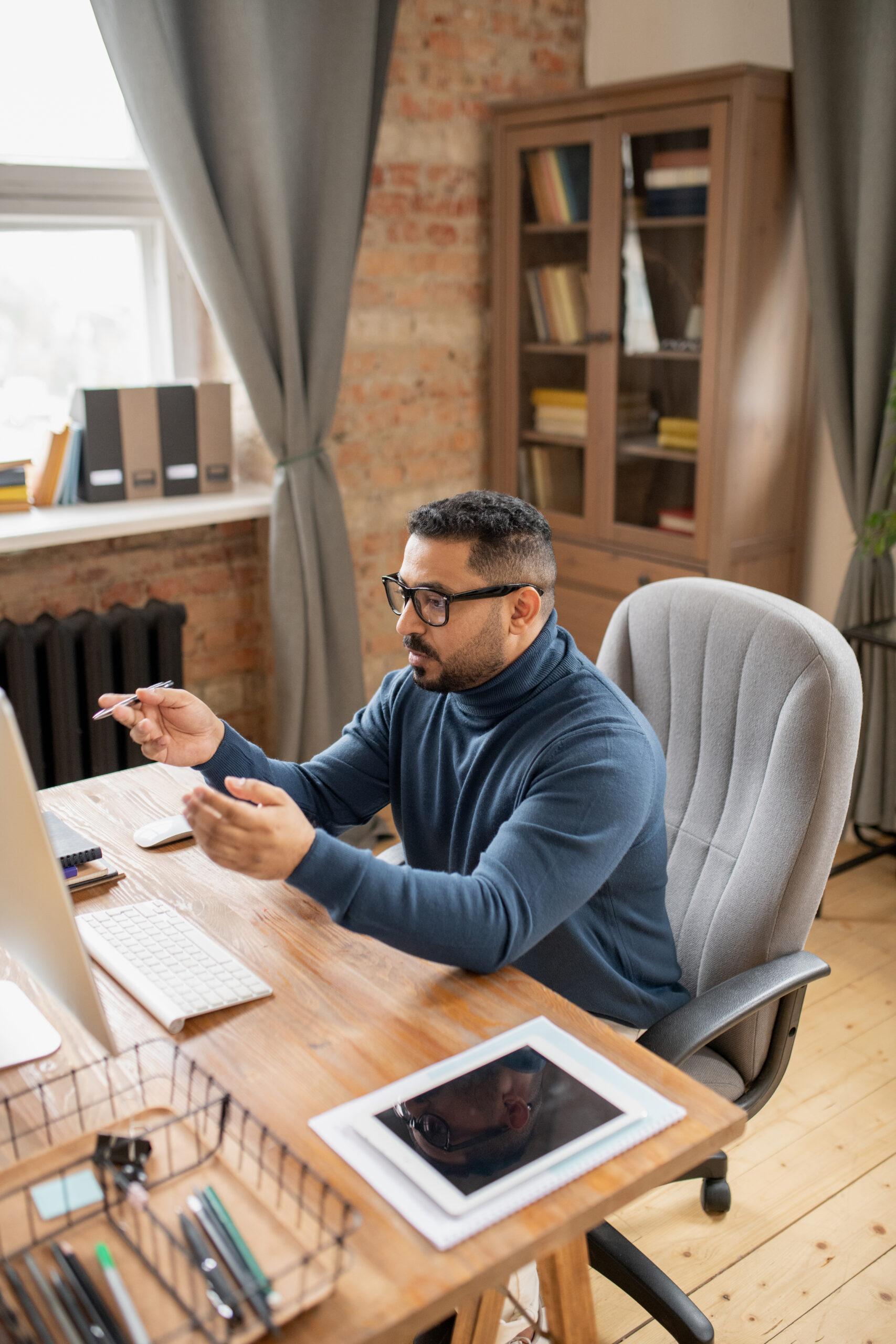 Mature confident male teacher sitting in front of computer